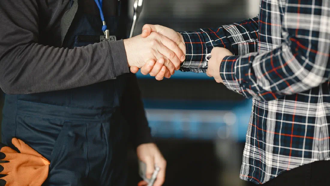 Poignée de main avec un carrossier de confiance dans un atelier à Matane